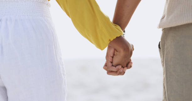 istock Couple, people and outside or holding hands on beach, relationship and commitment on weekend break together. Trust, support and love for bonding with partners, romance and nature with empathy 2164501045
