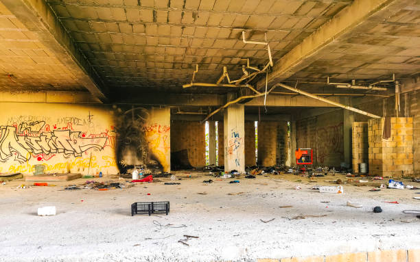 Interior of old factory buildings destroyed. Ruins of industrial enterprise, dark debris destroyed factory premises in factory as result of economic crisis and earthquake.