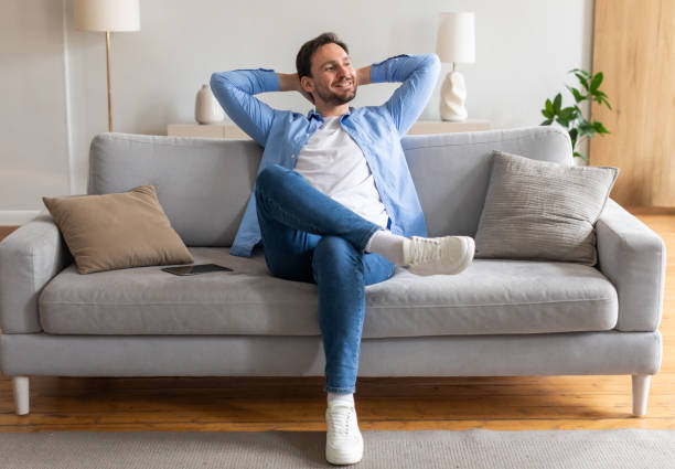 istock Man Sitting on Couch With Hands on Head 2164502212
