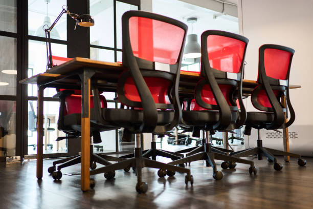 istock Multiple office chairs arranged at coworking desk 2164503327