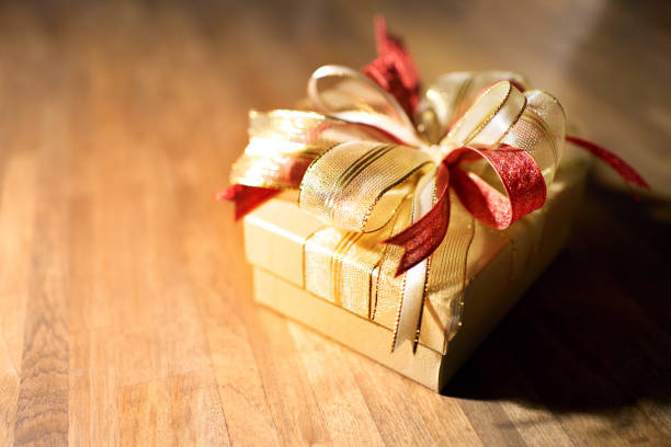 Small gift box elegantly wrapped with a ribbon on a wooden table