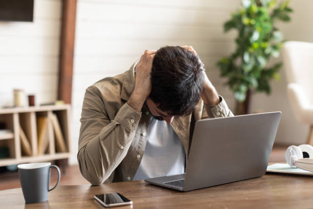 Frustrated Young Man Feeling Overwhelmed at Work During Early Hours