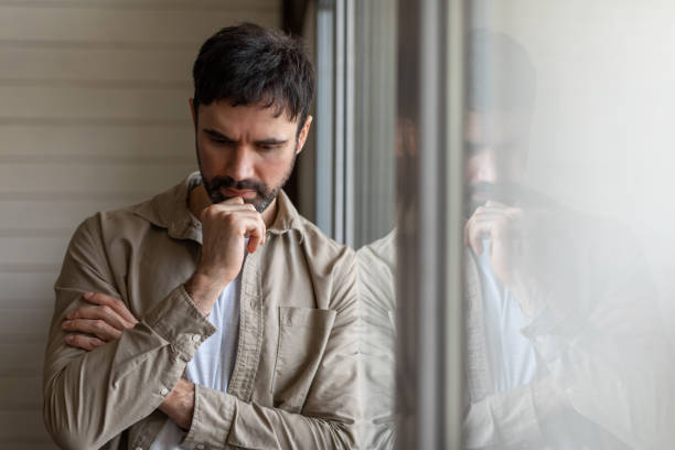 Man Contemplating, Standing in Front of Window