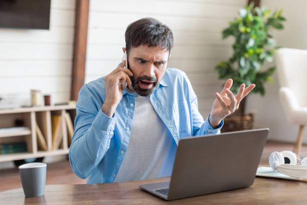 istock Frustrated Man Arguing on the Phone While Working on Laptop 2164504764