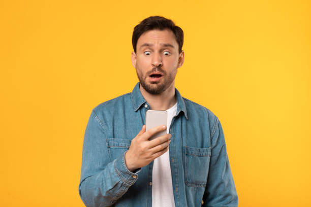 istock Man With Surprised Look Holding Cell Phone 2164506534