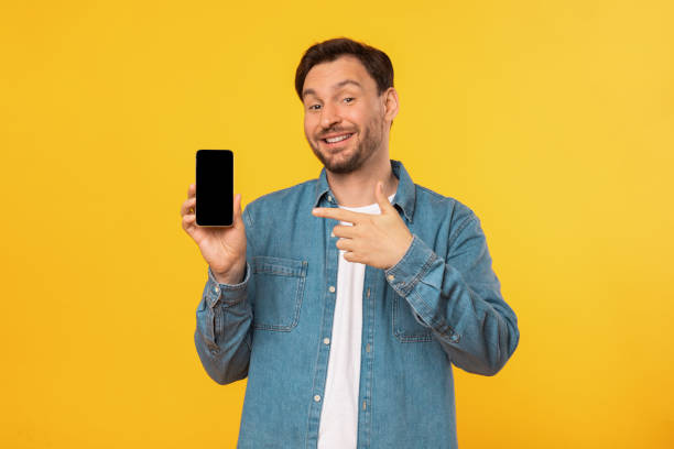 istock Man in Blue Shirt Holding Cell Phone With Blank Sceen 2164506559