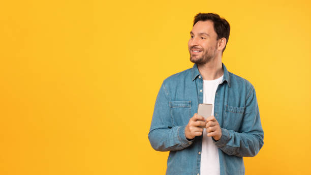 istock Man in Blue Shirt Holding Cell Phone, Empty Space 2164506575