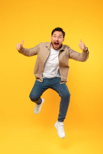 istock Man Jumping in the Air With Hands Raised 2164506626
