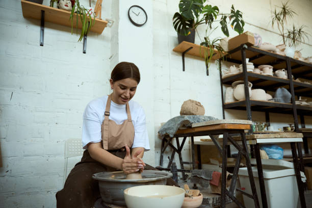 istock Happy young woman making ceramic pot on potters wheel 2164507960