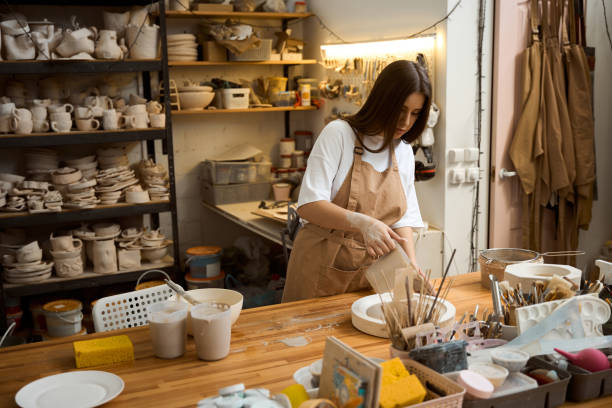 istock Craftswoman pouring gypsum into the silicone mold in workshop 2164508632