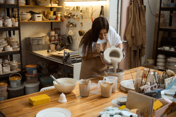istock Female pouring pottery mixture from a mold in workshop 2164508694