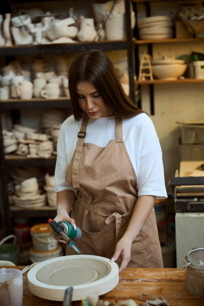 istock Woman master in an apron ceramics handmade in a workshop making dishes 2164508707