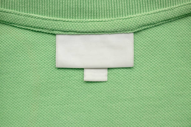 istock White blank laundry care clothes label on green shirt fabric background 2164523441