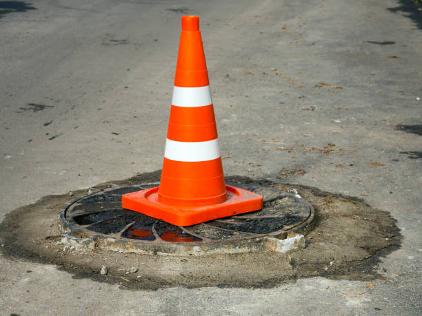 istock A traffic cone that draws attention to a manhole protruding above the road surface 2164535140