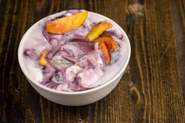yogurt with jam and pieces of ripe nectarine, natural yogurt in a white bowl with fruits