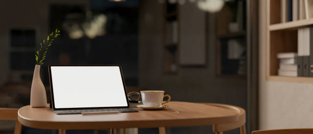 istock A tablet with a white-screen mockup and wireless keyboard on a wooden table in a room at night. 2164546845