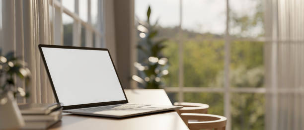 istock A laptop computer mockup on a minimal wooden table in a room with sunlight. 2164546885
