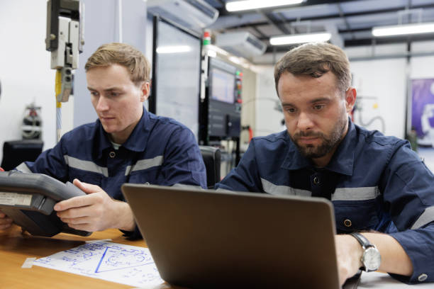 istock Two engineer sits in a research lab analyzing the performance of a robotic arm. 2164548496