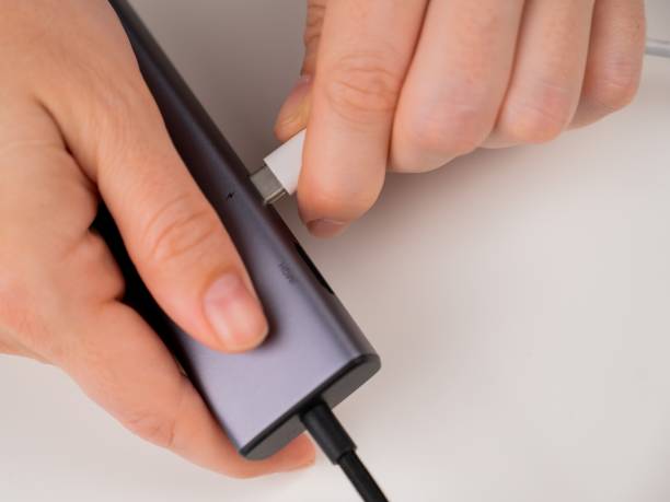 istock A woman inserts a white Type C cable into a black port. 2164561117