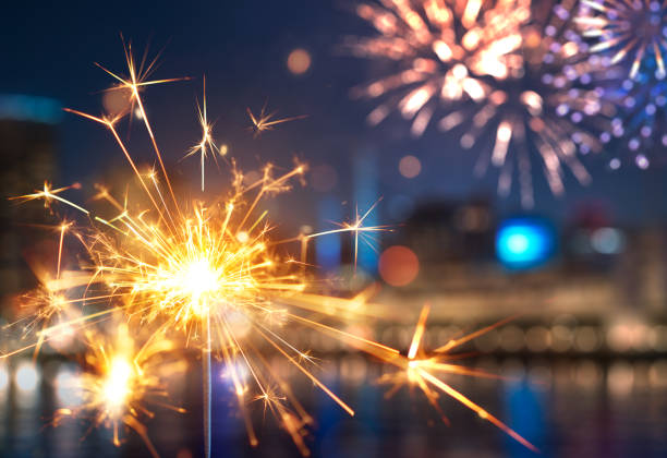 istock Sparkler with blurred fireworks light up the night sky during New Year celebration 2164570494