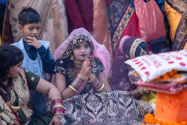 Ghaziabad, Uttar Pradesh, India - November 2023: Chhath Puja, Group of indian woman sitting on ground to perform the rituals of chhath puja in traditional ethnic clothes.