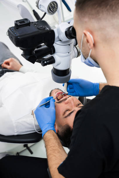 istock Polishing teeth under a digital microscope process. Dentist uses dental polisher hardware and mirror to whiten teeth of the patient. 2164573019
