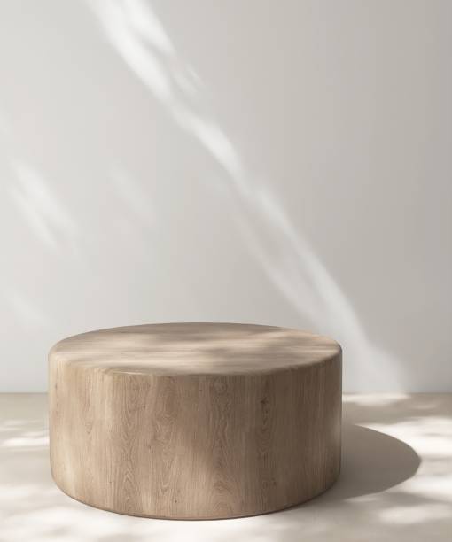 istock Modern, minimal cylinder wooden pedestal table podium in dapple sunlight, shadow on white wall, beige floor 2164580304