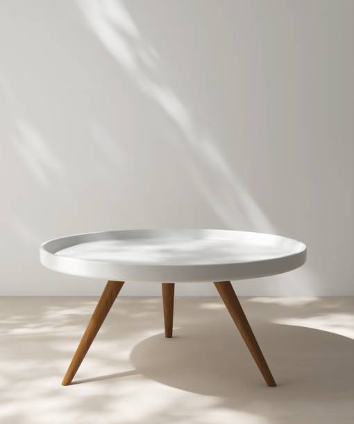 istock Modern, minimal white pedestal table podium, wooden leg in dapple sunlight, shadow on white wall, beige floor 2164580325