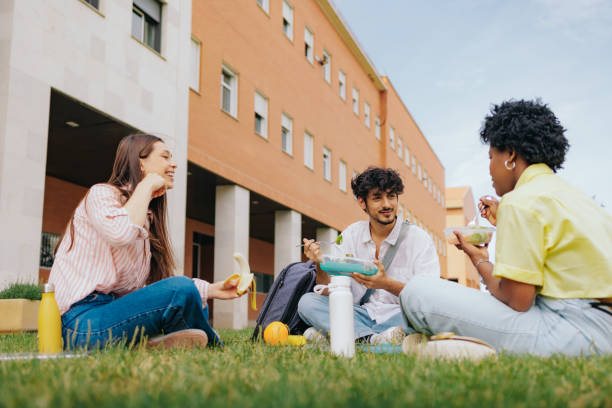 istock Three multiethnic students sitting in campus having lunch and enjoying friendship. 2164581268