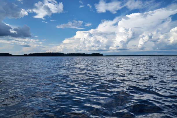 view from the boat on the river with waves and blue sky with white clouds