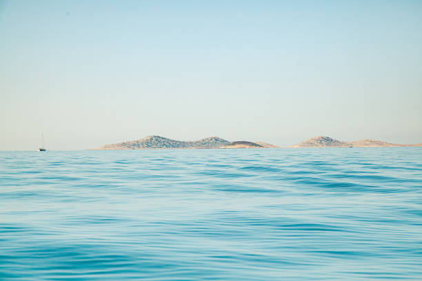The surreal panoramic island view of Kornati Island National Park in Dalmatia (Croatia) on a clear blue summer day with a bit of morning haze and very calm tranquil sea.
