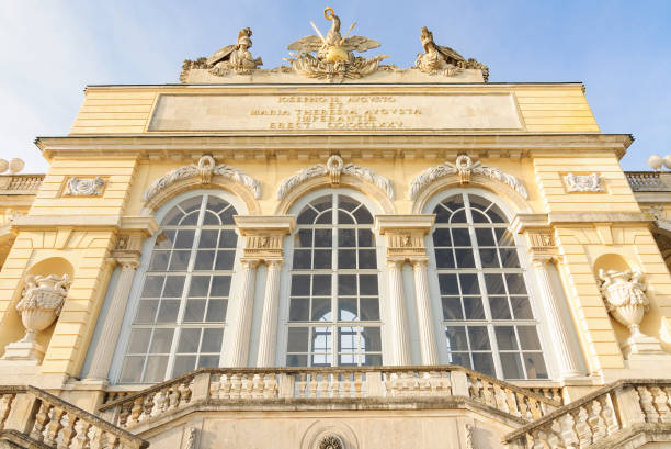 Vienna, Austria  April 8, 2011: Gloriette Frontage in Schonbrunn Palace Gardens. A gloriette is a building in a garden erected on a site that is elevated with respect to the surroundings. The largest and probably most well-known gloriette is in the Schonbrunn Palace Garden in Vienna. It was built in 1775 as the last building constructed in the garden according to the plans of Austrian imperial architect Johann Ferdinand Hetzendorf von Hohenberg.\nThe front face bears the following inscription:\nIOSEPHO II. AVGVSTO ET MARIA THERESIA AVGVSTA IMPERANTIB. ERECT. CIICCLXXV.\n(Erected under the reign of Emperor Joseph II and Empress Maria Theresa, 1775.)