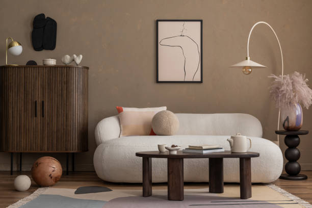 istock Creative composition of aesthetic living room interior with mock up poster frame, boucle sofa, wooden sideboard, coffee table, marble lamp, brown wall and personal accessories. Home decor. Template. 2164585067