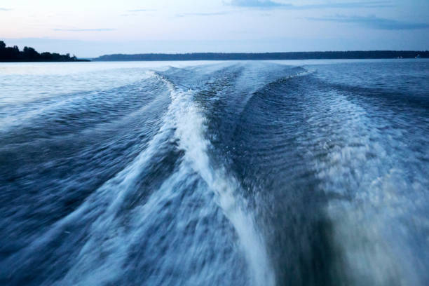 Couple drift down river in fishing boat at dusk, guided fishing tour for salmon and steelhead, Washington State