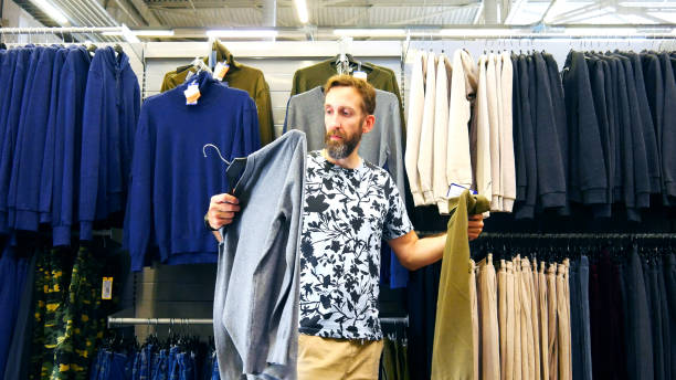 istock A male buyer holding pullover and turtleneck wondering what to choose 2164588767