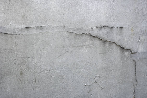 istock A grey wall with cracks and holes 2164590825