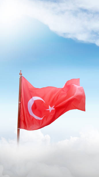 A Turkey flag with a white star and crescent moon flying in the sky
