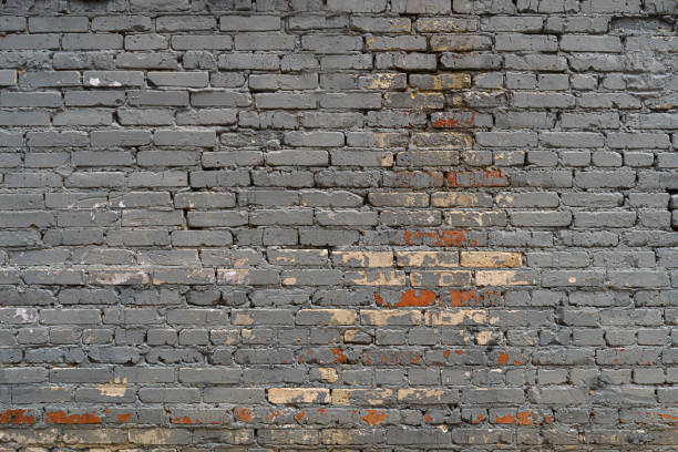 The brick wall is painted with gray paint. Abstract construction background.