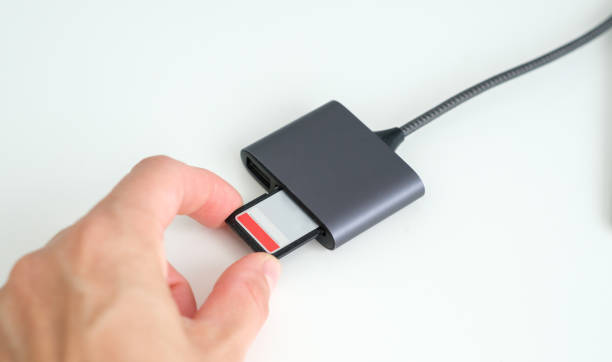 istock Hand inserting memory card into laptop slot on white background 2164594093