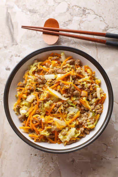 istock Spring roll bowls packed with pork mince and fresh veggies closeup on the table. Vertical top view 2164594479