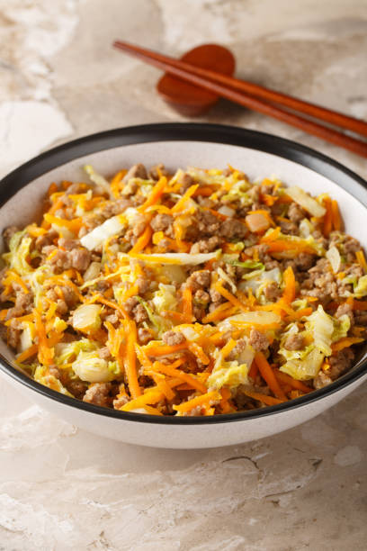 One Pot Egg Roll Bowl with beef, onion, carrot, cabbage closeup. Vertical