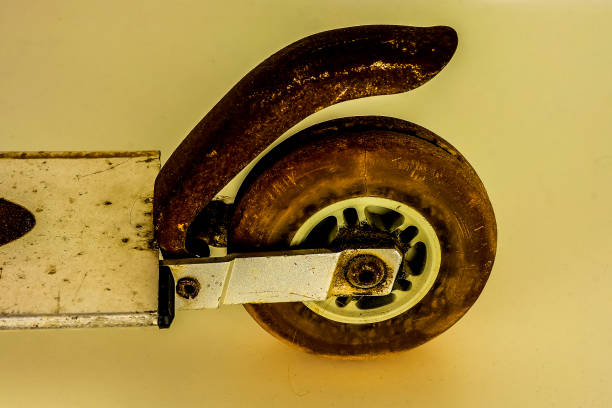 A rusty skateboard wheel is shown in the foreground of the image. The wheel is old and worn, with a brown and black color scheme. The skateboard itself is not visible in the image