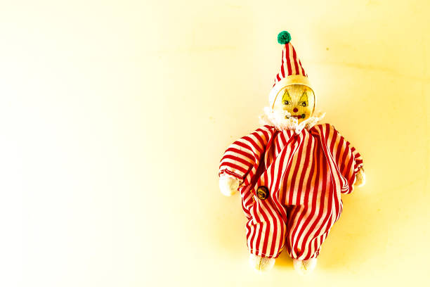 istock A small, red and white clown doll is sitting on a white background 2164602559