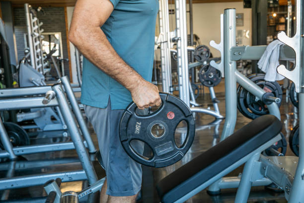 istock Middle-aged Man in Gray Workout Attire Holding a Dumbbell 2164602917