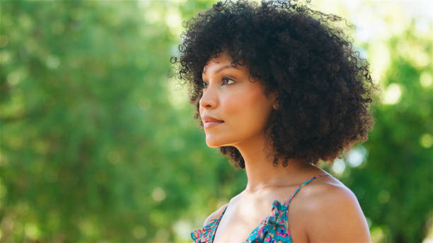 istock Young Woman Posing Outdoors in Natural Light Surrounded by Lush Greenery During a Bright Sunny Day 2164606080