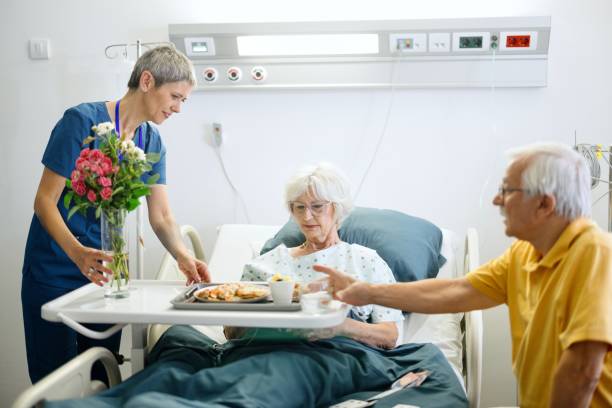 istock Nurse giving lunch to a senior patient 2164610022