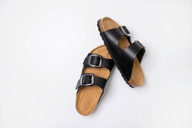 istock Black leather sandals with cork soles on a white background, top view flat lay. Trendy fashionable summer clogs, unisex sandals. Minimalism style 2164610093