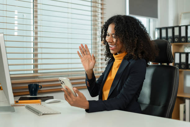 istock Happy African woman having fun doing video call using smartphone in office during free time. 2164610201