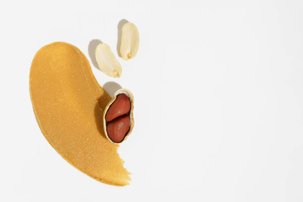 istock Texture of peanut paste and whole nuts on white isolated background. Place for your text or design. Background with peanut butter 2164616739