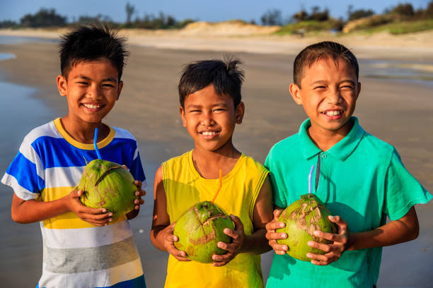 istock Vietnamese children holding coconuts on the beach, Vietnam 2164620833
